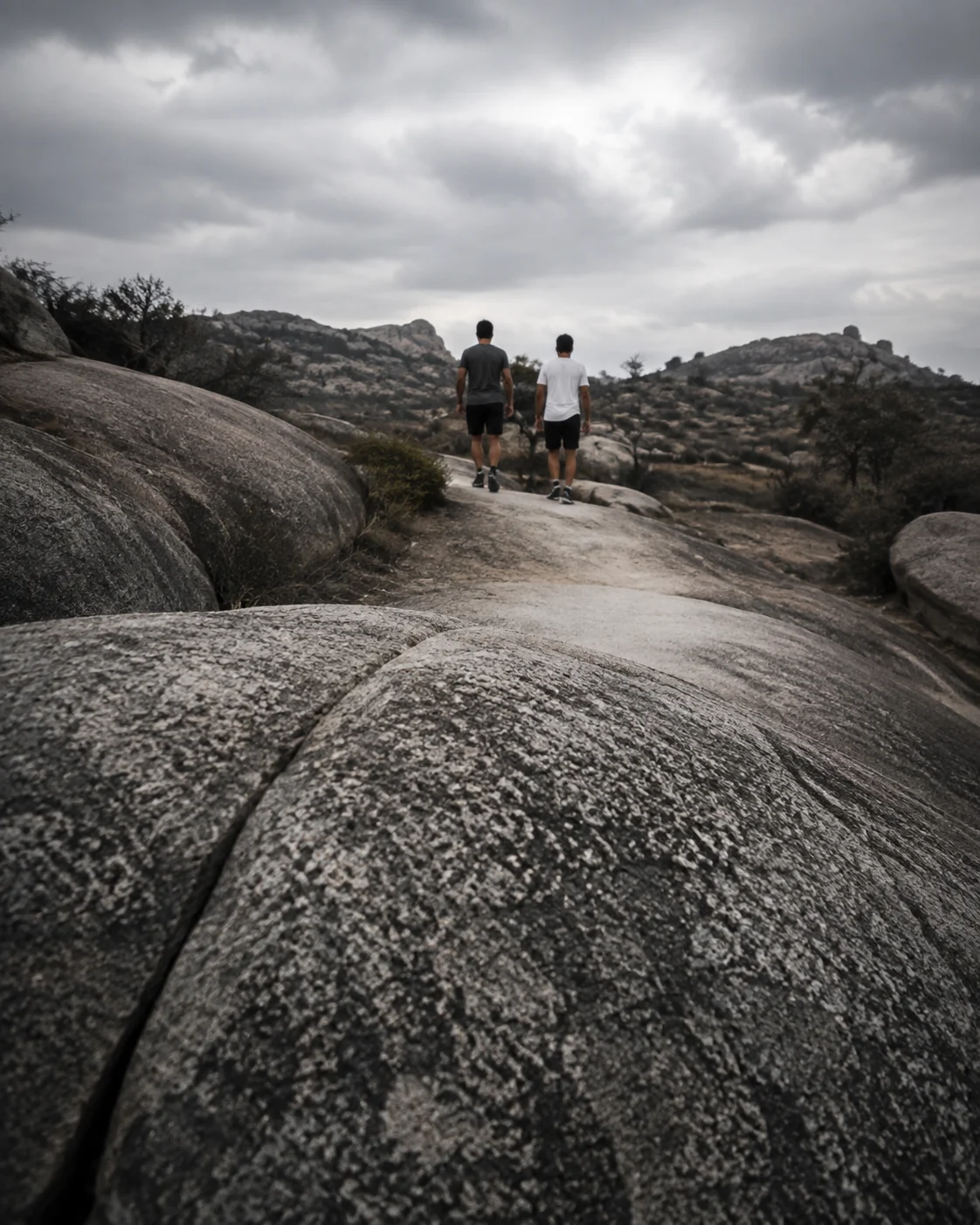 Two runners following a granite trail into the hills, a campaign scene